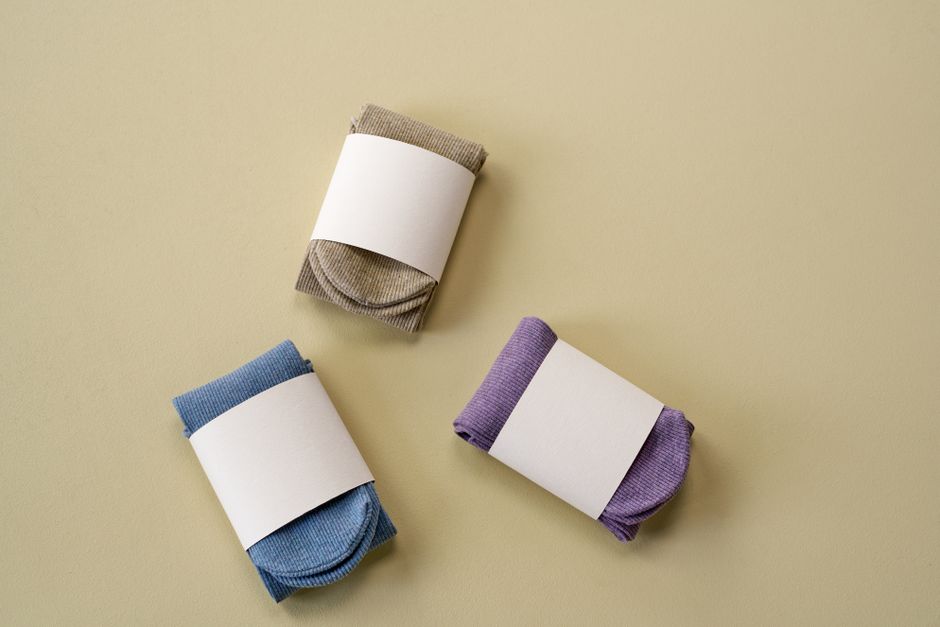 A flat lay of packaging components including box, label, and tissue.