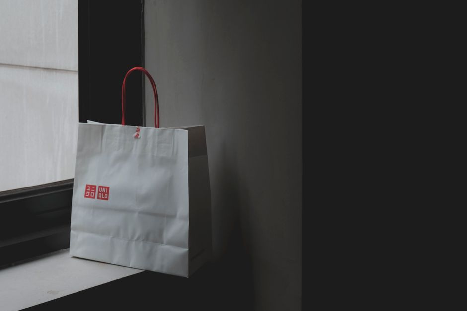 A branded paper shopping bag with a logotype printed on it.